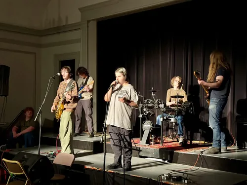 Members performing on stage at a BSLC concert