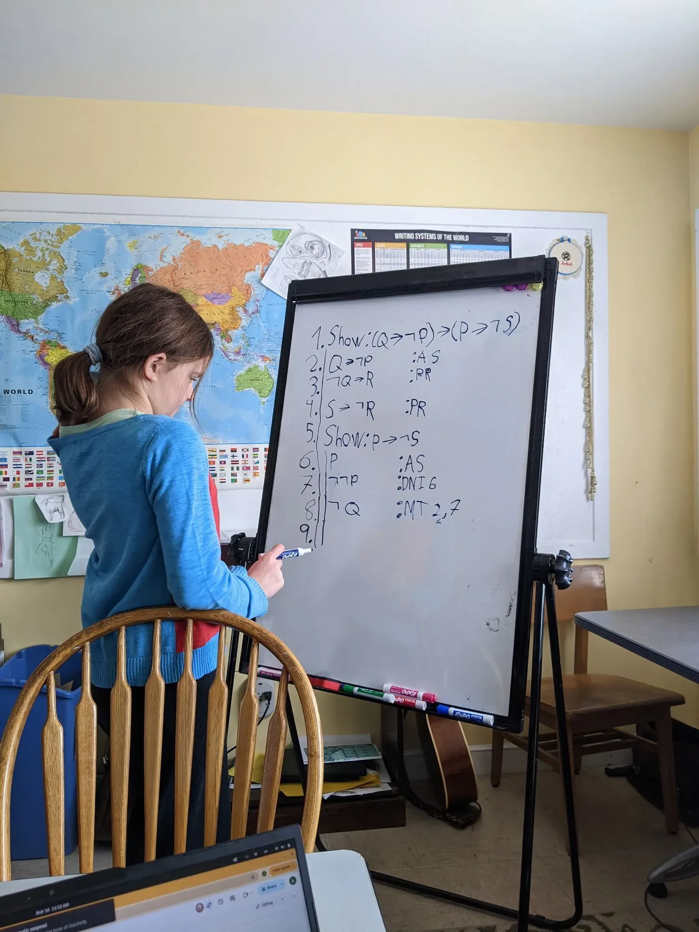 A student working through a logic proof on a whiteboard