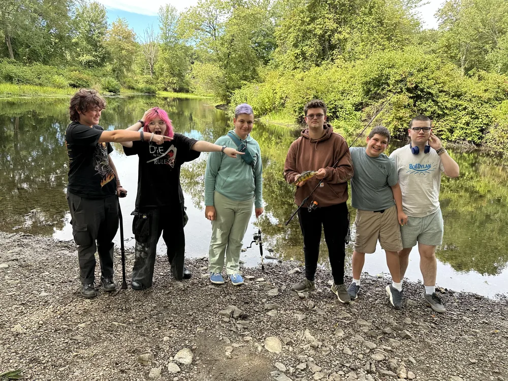 Teenagers pose for a picture while fishing.